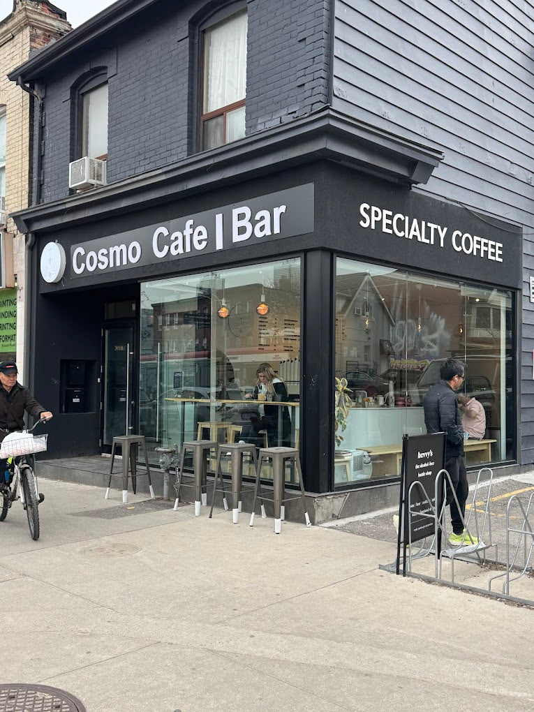 Cosmo Cafe Bar with people outside on a sidewalk